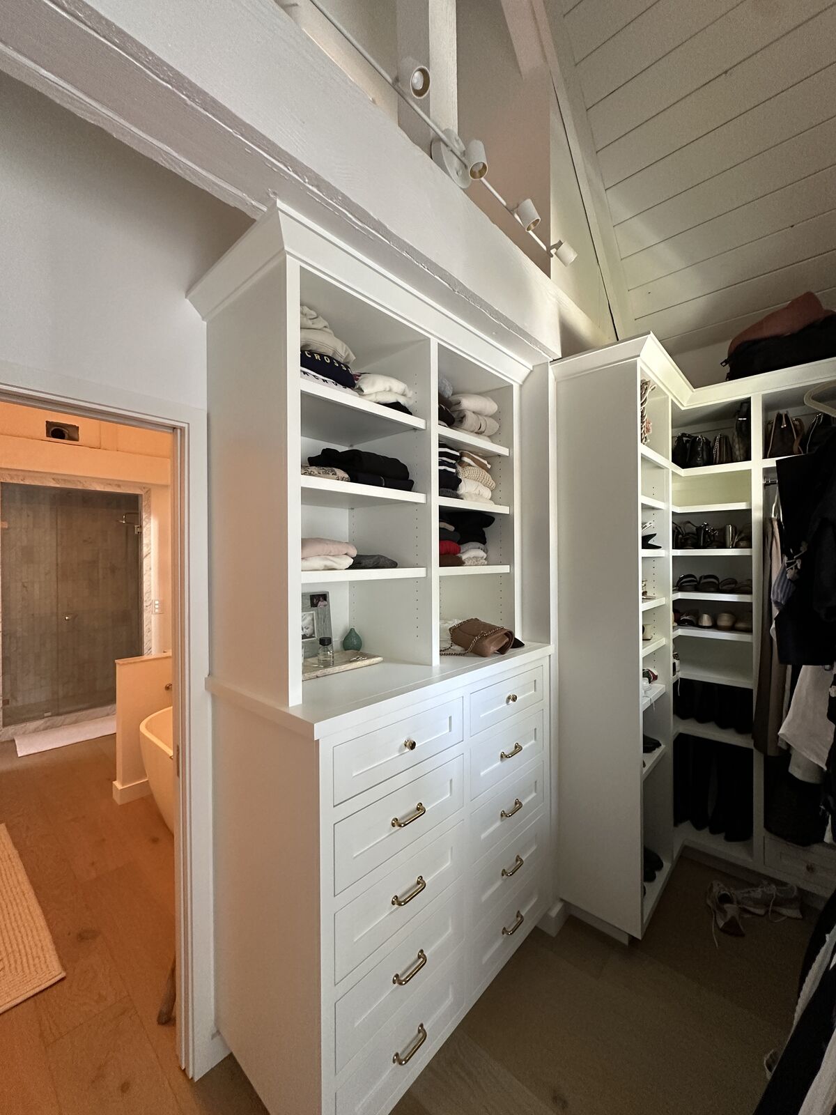 Custom white built-in closet cabinetry with drawers and open shelving by PRDI