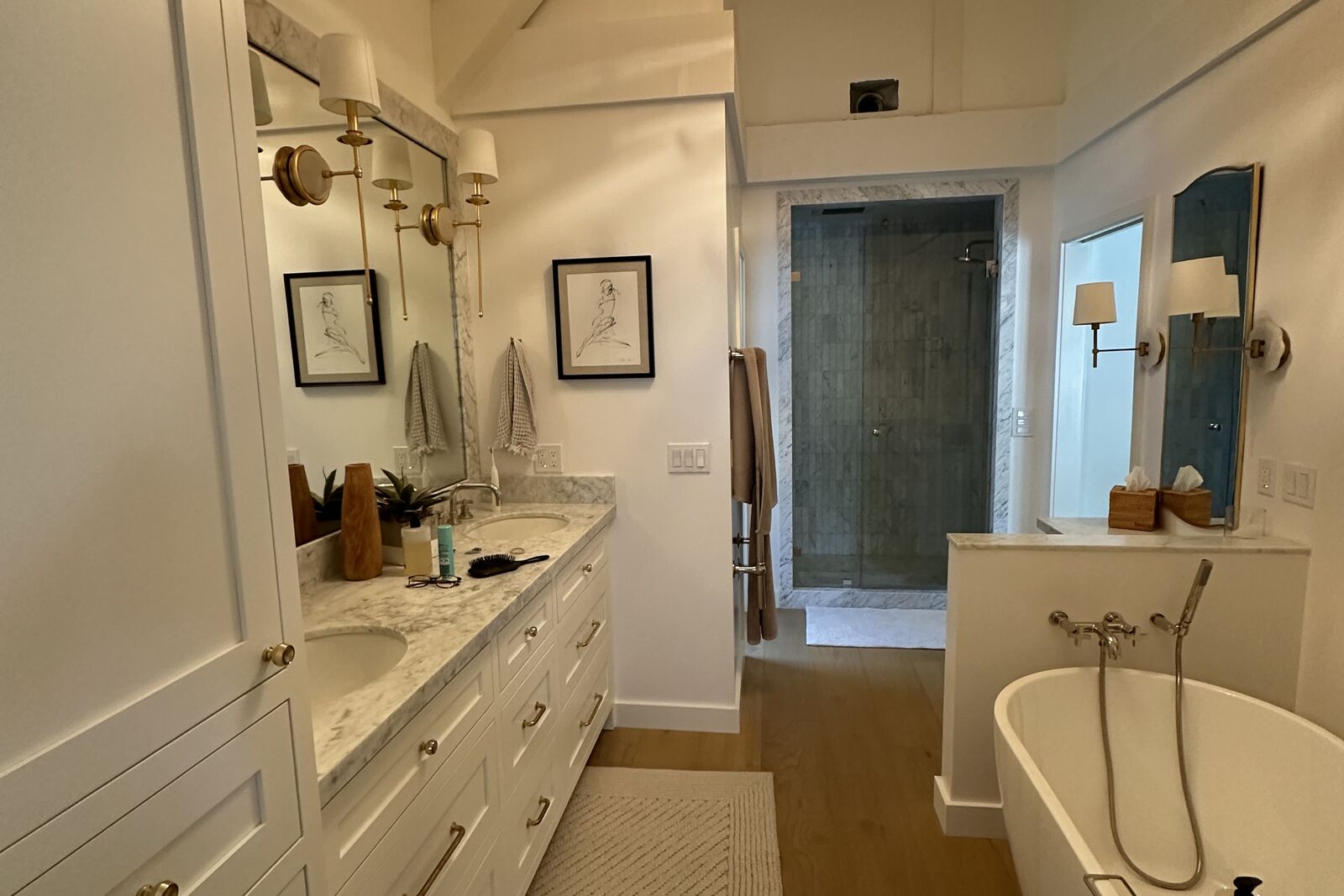 Completed PRDI primary bathroom with freestanding tub, custom vanity cabinetry, and white oak floors