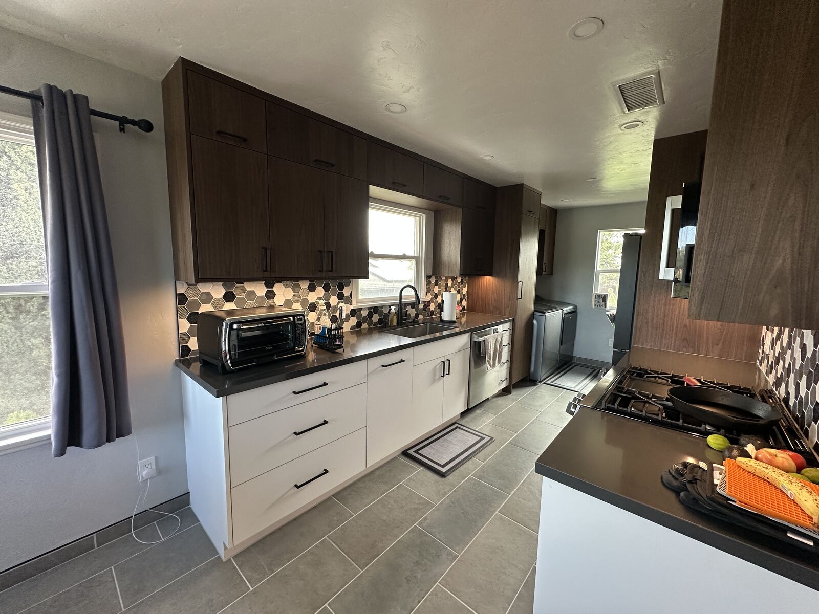Completed PRDI kitchen remodel with walnut and white cabinetry and dark quartz countertops