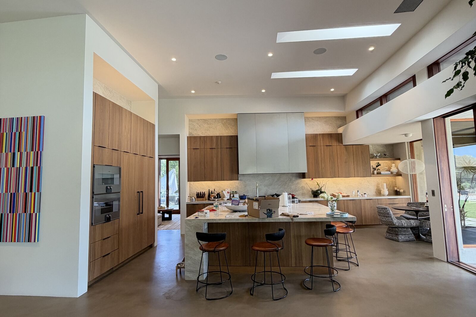 Completed PRDI great room kitchen with walnut cabinetry, large island, and skylights