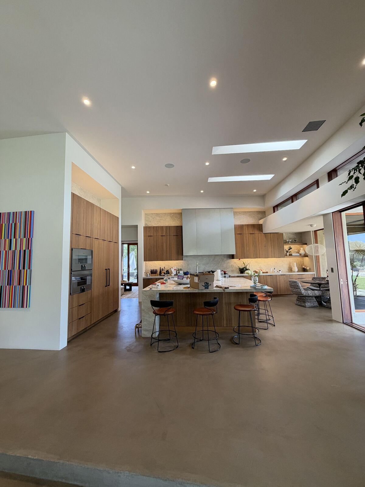 Completed PRDI great room kitchen with walnut cabinetry, large island, and skylights